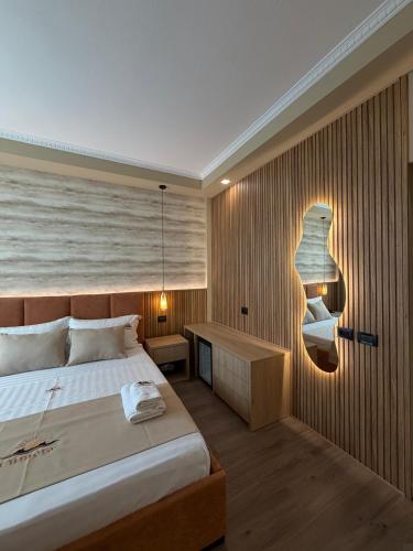 a bedroom with a large bed and a desk at Lumera Hotel in Durrës