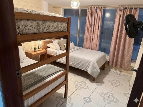 a bedroom with two bunk beds and a table at Casa en Tonsupa in Tonsupa