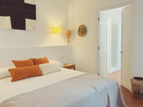 a bedroom with a bed and a clock on the wall at Hotel Casa Fiets in Alaior