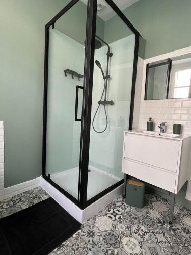 a shower with a glass door in a bathroom at Maison de ville in Évron