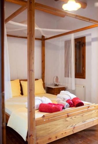 a wooden bunk bed with red pillows on it at Alexis new villas in Chrysi Ammoudia