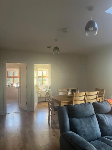 a living room with a couch and a table and chairs at The Cuckoos Nest - 2 bedroom in Headford
