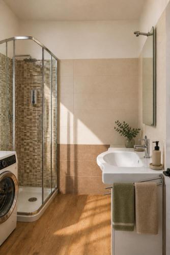 a bathroom with a shower and a sink and a washing machine at Home Istria 81 in Trieste