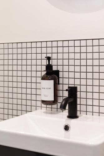 a bottle of soap sitting on a bathroom sink at Check In Belfast in Belfast
