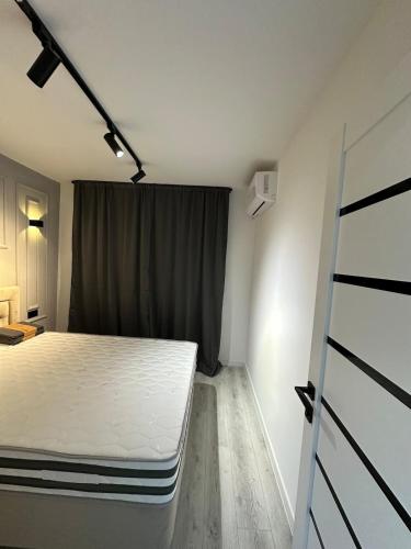 a bedroom with a white bed and a window at Renovat si stilat pentru un sejur de exceptie in Ungheni