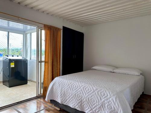 a bedroom with a bed and a sliding glass door at donde la abuela Josefa in Quimbaya