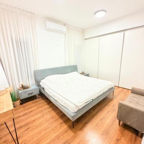 a bedroom with a bed and a couch at Geron's וילת אירוח in Bet Sheʼan