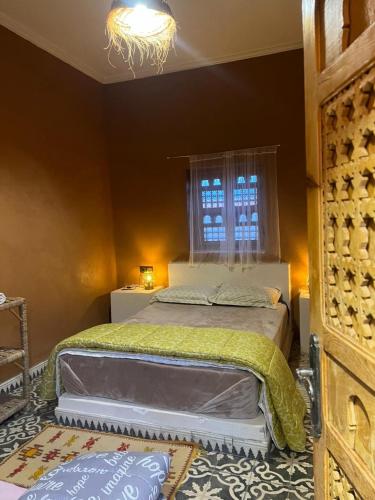 un dormitorio con una cama grande y una ventana en Tigmi Timhar, en Nkob