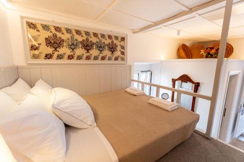 a bedroom with a bed with white pillows at Vasiliko House in Kalavárda