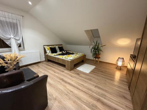 a living room with a bed and a couch at Attic Apartment in Kočovce