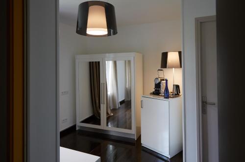 a room with a mirror and a lamp and a hallway at The Originals Hôtel Le Cise Restaurant Chambres et Suites in Ault