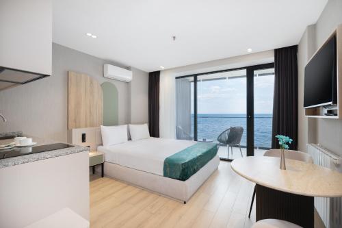 a hotel room with a bed and a view of the ocean at Marina Club in Batumi