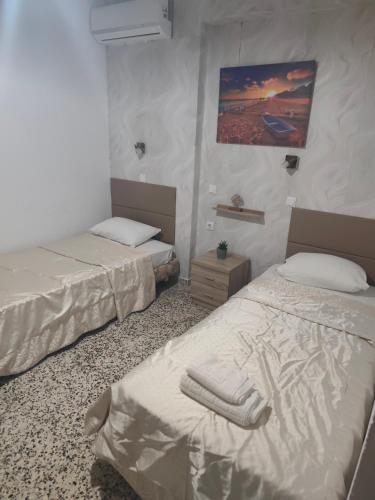 a room with two beds and a painting on the wall at Garden Studios N3 in Archangelos