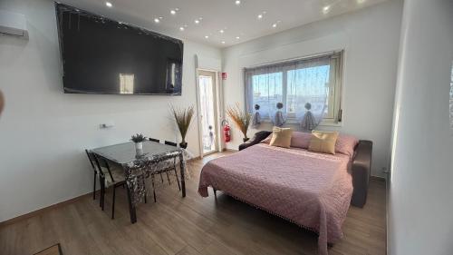a bedroom with a bed and a table and a television at Un Tuffo nello Stretto in Villa San Giovanni