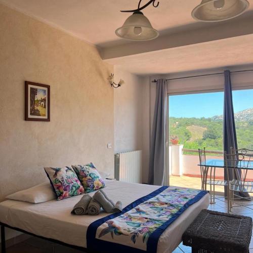 a bedroom with a bed with a view of a balcony at Villa Rosa in Surrau in Arzachena