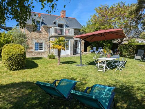 a house with a table and chairs and an umbrella at La Jeannette in Vains