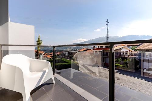 a white chair sitting on top of a balcony at Casa entre Rios in Alpendurada