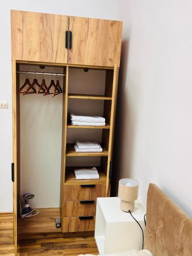 a closet with a wooden shelf with shoes at November Central Studio in Lugoj
