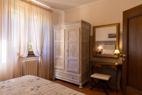 a bedroom with a dresser and a mirror and a bed at Casa Angolo delle Rose 2 in Orvieto