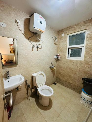 a bathroom with a toilet and a sink at Kishori Ji Homes in Chhatikara