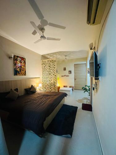 a bedroom with a bed and a ceiling fan at Kishori Ji Homes in Chhatikara