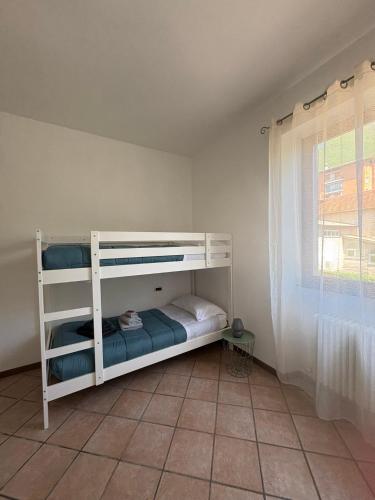 a white bunk bed in a room with a window at Casa Chiara in Mandello del Lario