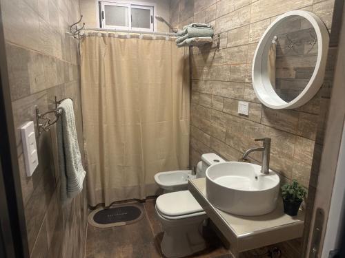 a bathroom with a sink and a toilet and a mirror at Aqui es 7 !! in Banfield