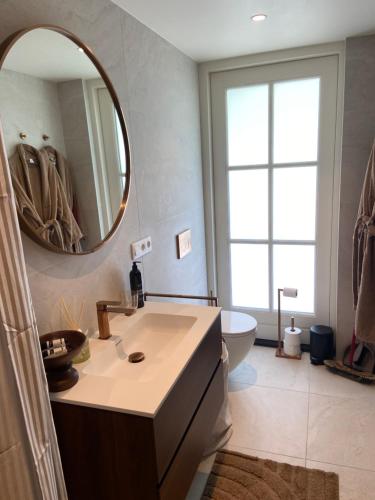 a bathroom with a sink and a mirror and a tub at Gastenverblijf Het Groene Hart in Lanaken