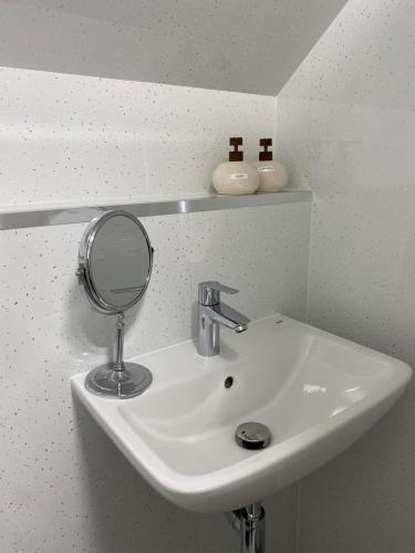 a bathroom sink with a magnifying mirror on it at Ladysmith Guest House in Ullapool