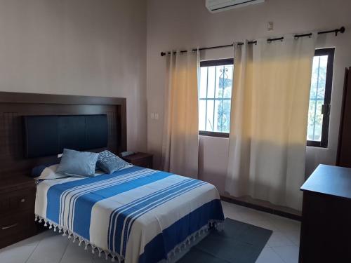 a bedroom with a bed and two windows at Finca la Esperanza in Guadalupe
