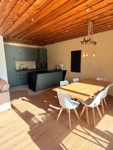a dining room with a wooden table and white chairs at Das Haus am See - der idyllische Privatsee nahe Wien in Tulln