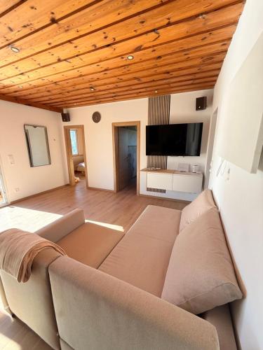 a living room with a couch and a flat screen tv at Das Haus am See - der idyllische Privatsee nahe Wien in Tulln