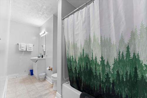 ein Badezimmer mit einem Duschvorhang mit Waldmotiv in der Unterkunft Balmoral Hotel in Barrys Bay