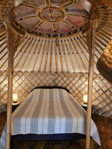a bed in a yurt with a wooden ceiling at Yourte Corsica vera in Appietto
