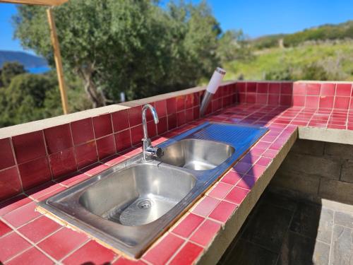 a kitchen sink with a red tiled counter top at Yourte Corsica vera in Appietto