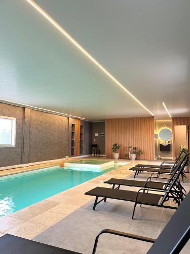 a swimming pool with a row of chairs in a building at Alamo Hotel in Villa Carlos Paz