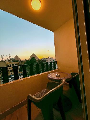 a balcony with a table and a view of the pyramids at Arte Pyramids Hotel in Cairo