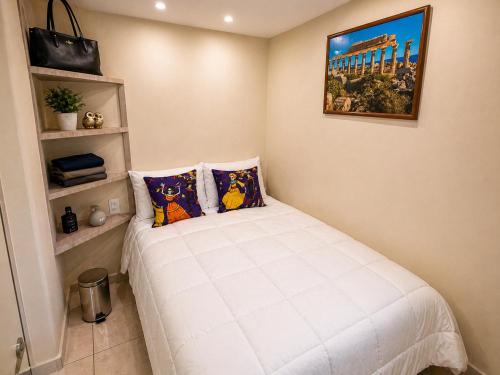 a bedroom with a white bed with two pillows at Habitación individual con baño privado a 3 Min del Estadio Azteca-Banorte y muy cerca de zona de hospitales in Mexico City