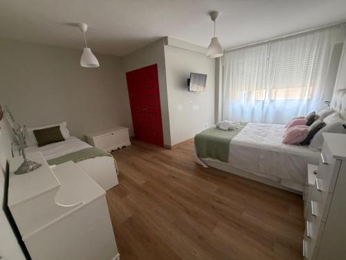 a bedroom with two beds and a red door at Monte y mar in Bueu