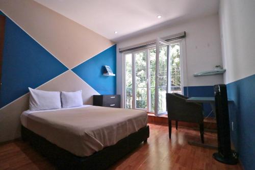 a bedroom with a bed and a desk and a window at MRE Goldsmith Polanco in Mexico City