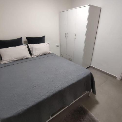 a bedroom with a large bed and a white cabinet at ויקשיין in Eilat