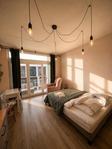 a bedroom with a bed and a desk and a chair at MIŁO Apartament Zarembowicza in Wrocław