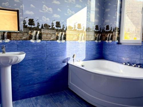 a blue bathroom with a tub and a sink at Кирч Горис in Goris