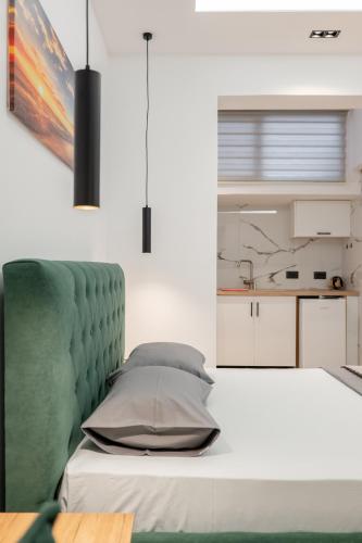 a bedroom with a bed with a green headboard at Villa Bella in Ksamil
