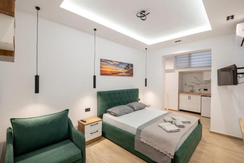 a bedroom with a bed and a green chair at Villa Bella in Ksamil