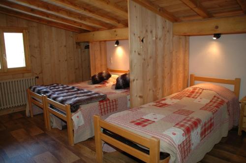 a bedroom with two twin beds in a cabin at Appartements Giffre et Clesson - DAHU COMPAGNIE in Samoëns