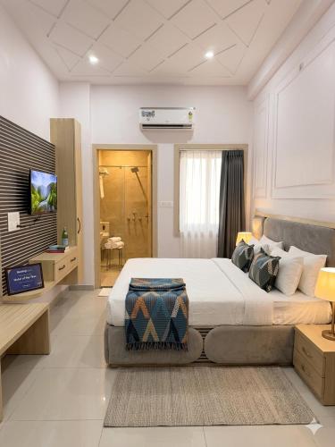 a bedroom with a large bed and a television at Sunrise stay in Chhatikara