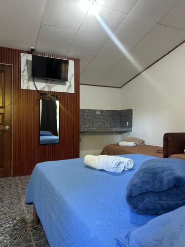 a bedroom with two beds and a flat screen tv at Restaurante y cabinas Sudy in Carara