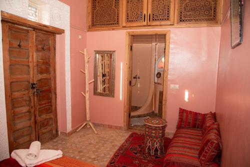 a living room with a couch and a mirror at Riad Rita in Meknès