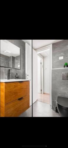 a bathroom with a sink and a wooden cabinet at דירה על הים in Ashdod